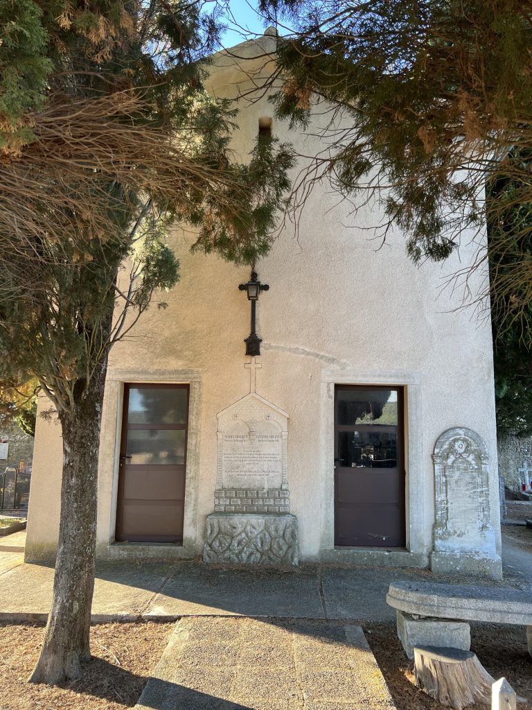 The Church of St. Margaret at the Old Town cemetery in Motovun, Croatia, sits amidst well-tended graves and tall cypress trees.